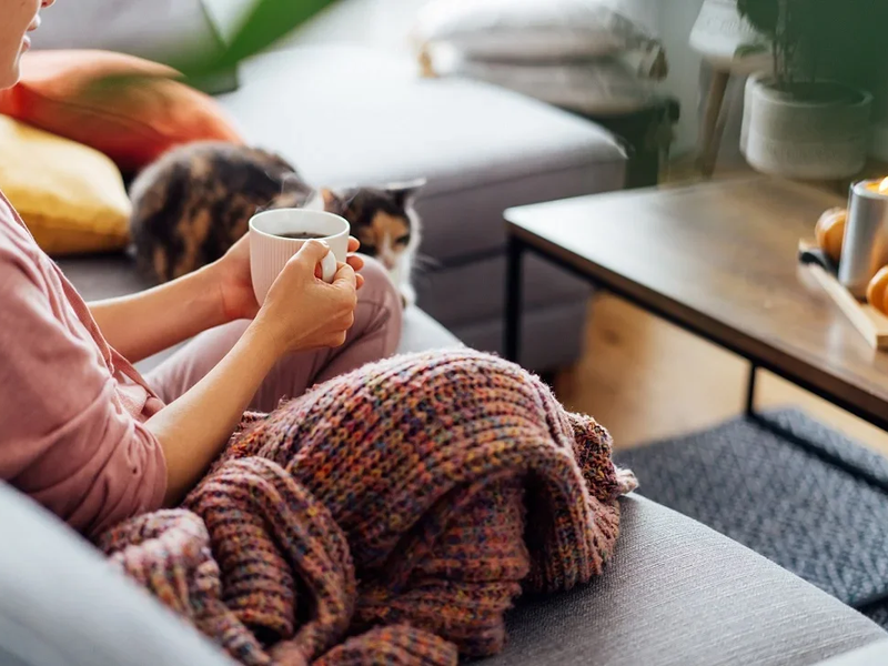 Woman sitting on the couch drinking a coffee